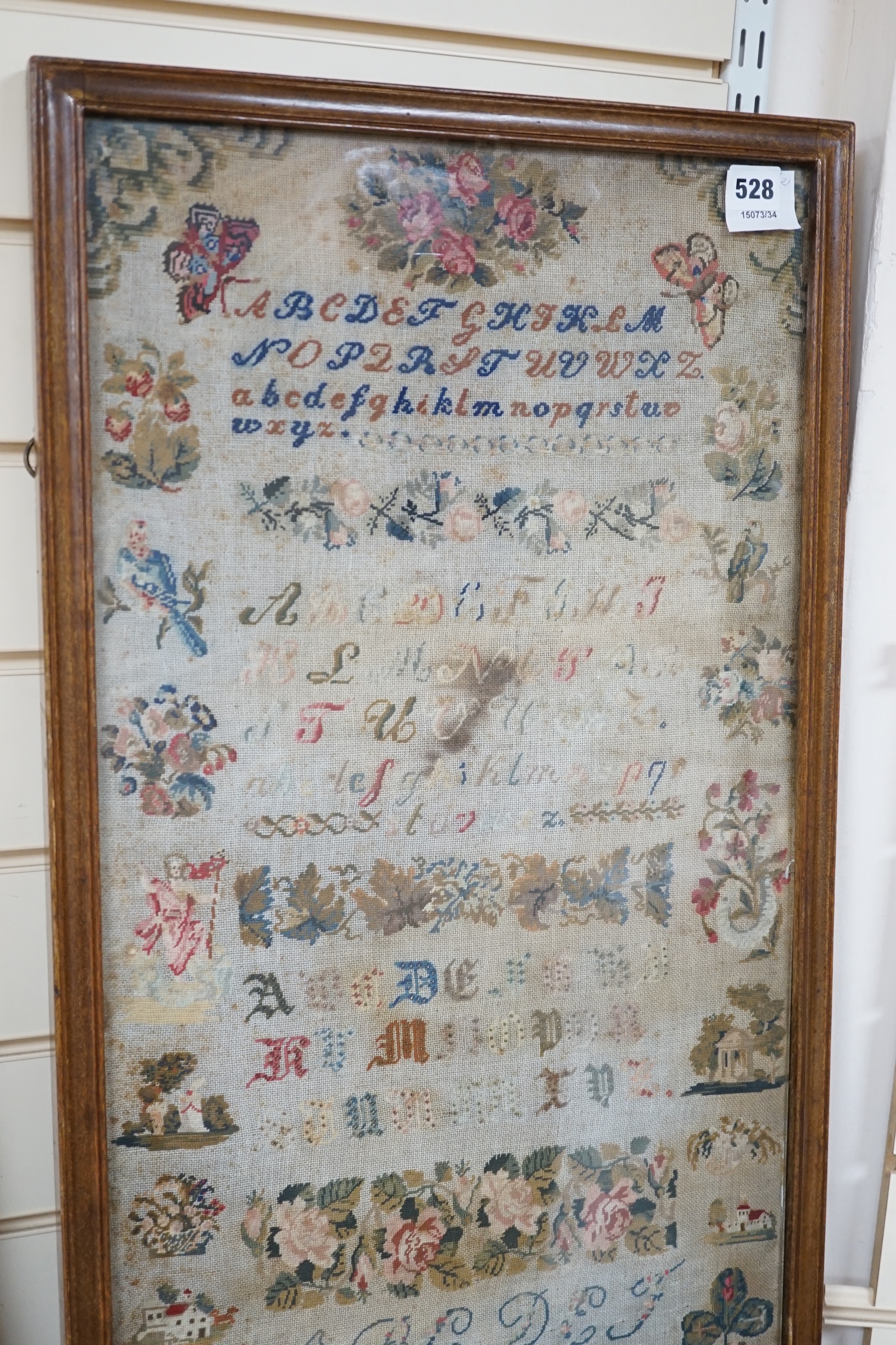 Two mid 19th century embroideries; a framed sampler dated 1809 and an embroidered figurative panel, largest 114 x 42cm. Condition - poor